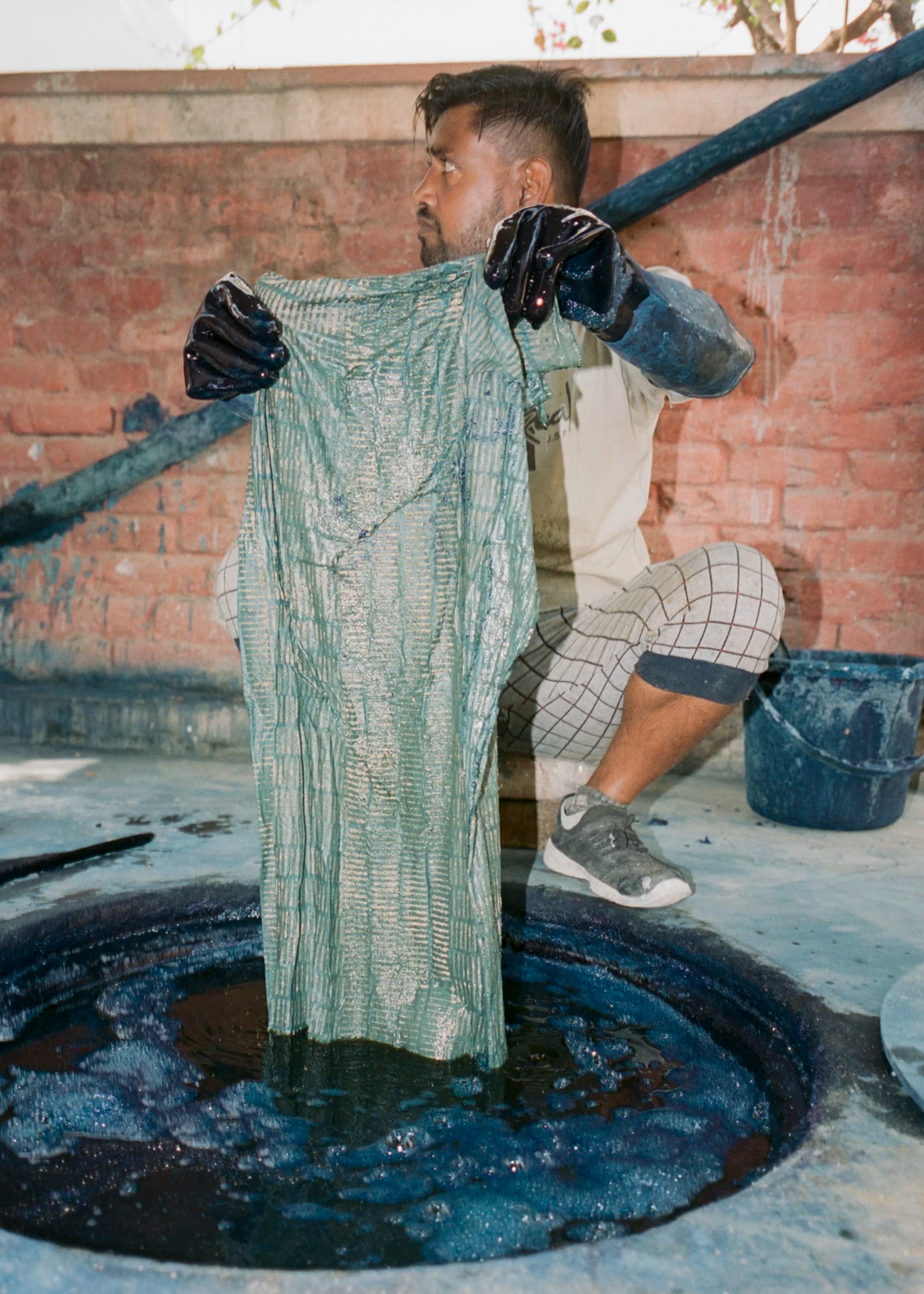Artisan lifting indigo dyed fabric