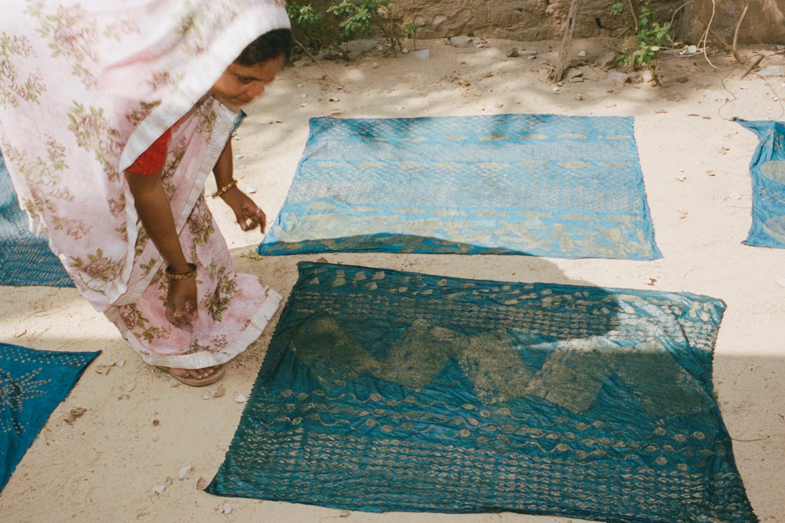 Woman in sari laying dyed fabric